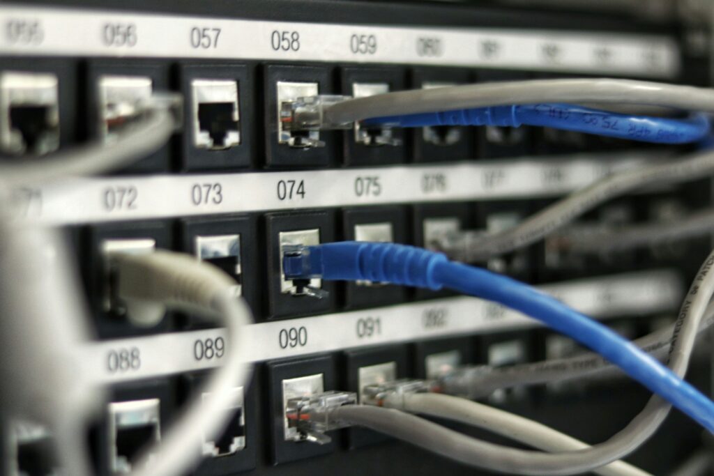 Network switch with blue ethernet cables illustrating IT infrastructure management.