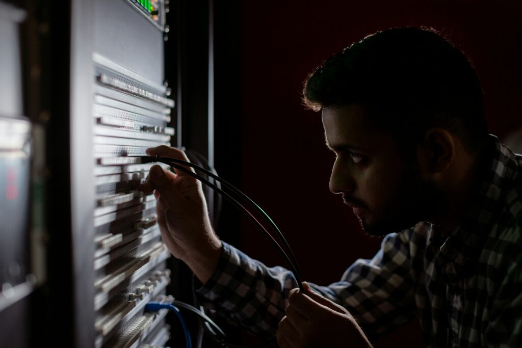 IT technician maintaining network server rack for TekNation network administration services.